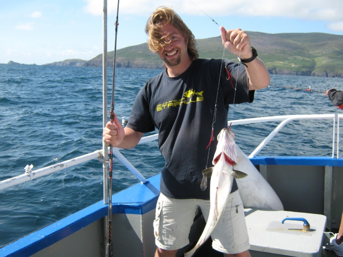 a person holding a fish on a boat in a body of water