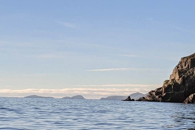 a large body of water with a mountain in the background