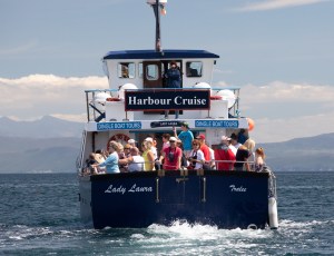 a group of people riding on the back of a boat in the water