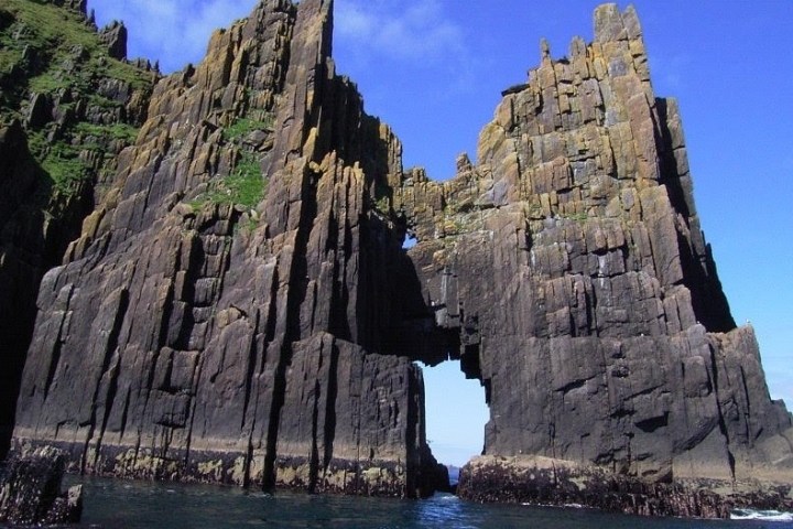 a large stone building with a mountain in the background