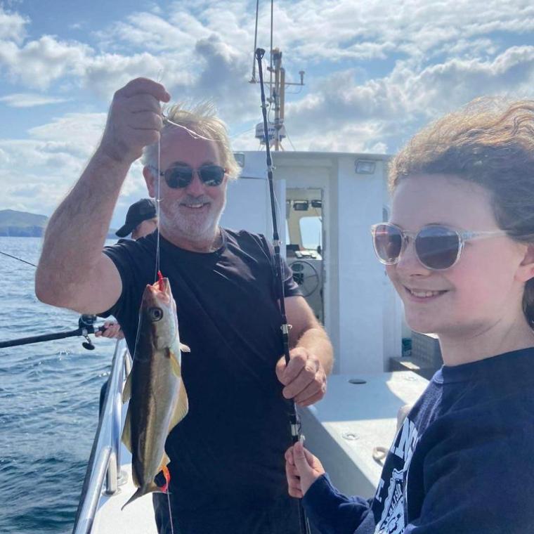 a man and a woman holding a fish in the water